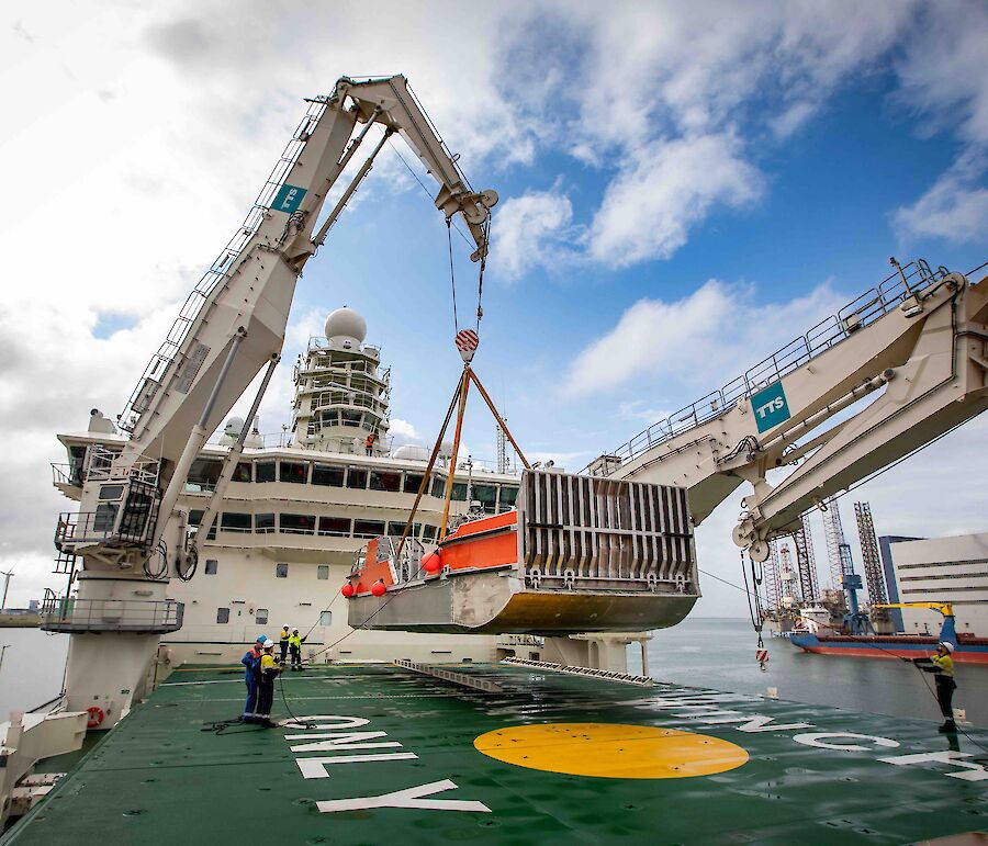 One of Nuyina's cranes lifting a barge on to the fordeck.