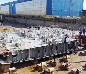 Placement of four conjoined blocks (deck of forward engine room and moon pool hull aperture) within the dry dock.