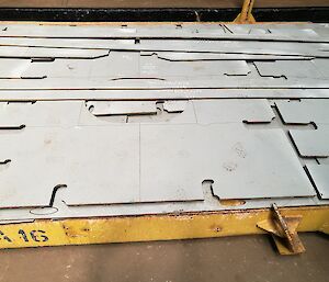 Flat steel plate with different shapes cut out.