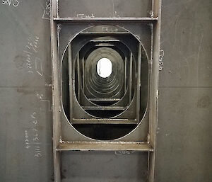 Layers of steel surrounding a port hole.
