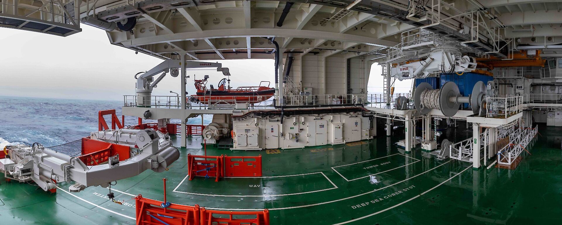 A deck on a ship filled with white and orange equipment.