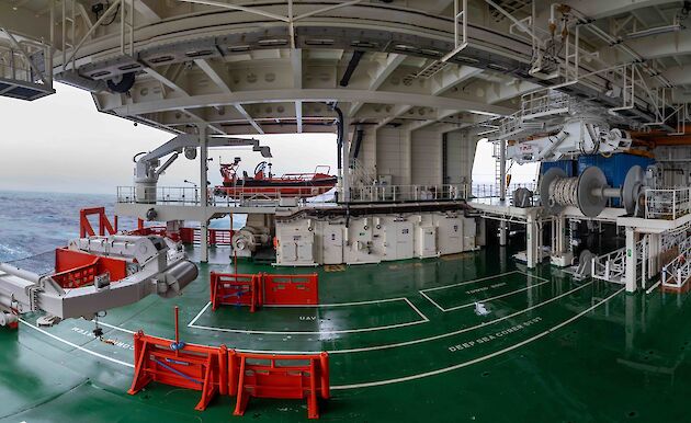 A deck on a ship filled with white and orange equipment.