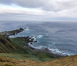 Steep hill with a track leading down to a grey ocean