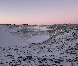 A lake visible in the distance of a snowy landscape