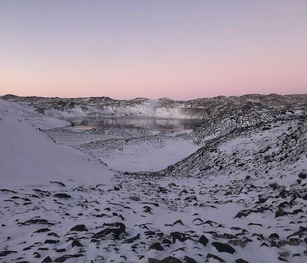 A lake visible in the distance of a snowy landscape