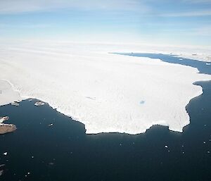An aerial image of an icy glacier where it meets the sea