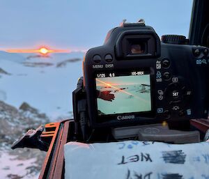 One of the permanent cameras being serviced with the sun passing along the horizon in the distance.