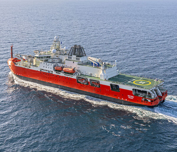 Orange and white icebreaker at sea