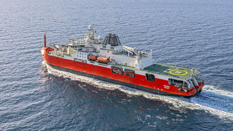 Orange and white icebreaker at sea