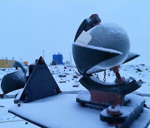 A piece of sun measuring equipment covered in snow.
