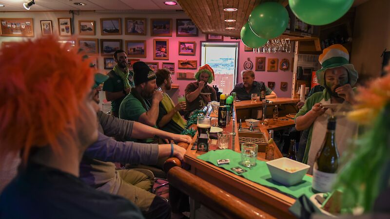 people with novelty wigs in green at bar