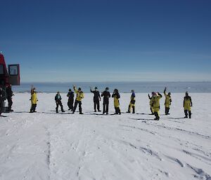 Group of expeditioners standing next to the red Terra bus on the snow covered icecap.