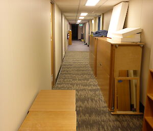 The down the long corridor with building materials up against the walls.