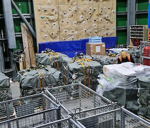 A large warehouse shed containing a number of airdrop pallets and storage cages.