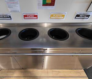 Stainless steel bins labelled for waste and recycling.