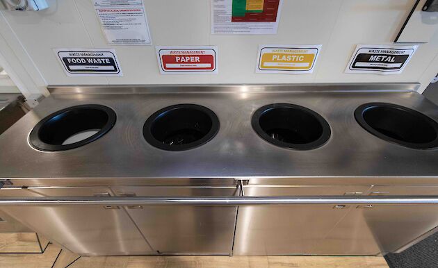 Stainless steel bins labelled for waste and recycling.