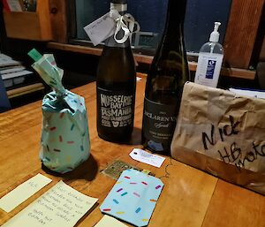 Birthday gifts on a table, together with a post-it note that reads "just because you escaped for your birthday does not mean you escape a birthday surprise - Happy hut birthday".
