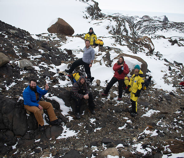 A group of people rest at the top of Stalker Hill smiling to camera.