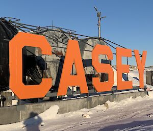 A new painted pristine large orange sign spelling CASEY