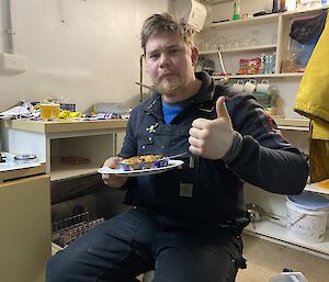 Expeditioner having his first Fray Bentos steak and kidney pie giving the thumbs up.