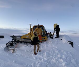 A group of people preparing to dig out a snowbound vehicle