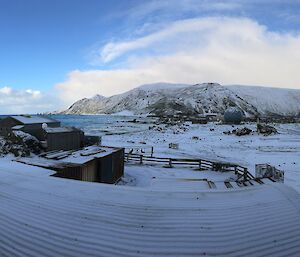 Snow settles across the island with blue sky and white cloud in the background