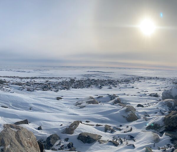 Panoramic shot of snow covered rocks lit by the sun