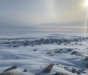 Spring sunshine softly lights up a rocky outcrop covered in snow