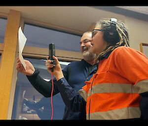 Two expeditioners singing into a microphone recording the soundtrack