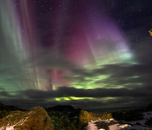 A beautiful pink and green aurora lighting up the sky above Macquarie Island