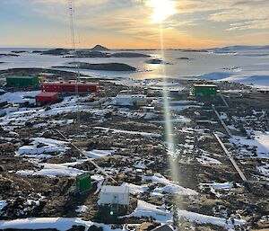 View of Mawson station from the top of the wind turbine with a beam of sunlight through the centre of the photo.
