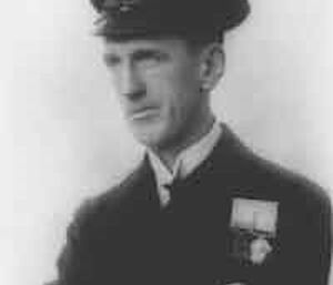 A black and white portrait shot of an man in a captain's uniform