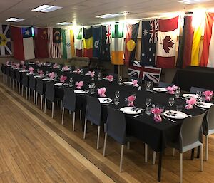 A long dining table set for midwinter 2021 with flags decorating the room