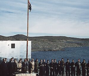 A group shot of the official flag raising for the opening of Davis station with a rocky outcrop in the background
