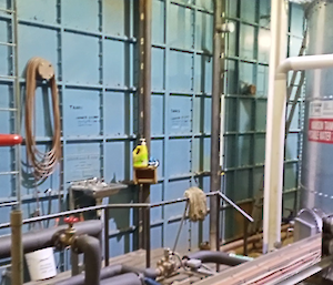 The remaining older water storage tanks painted blue with various pipes attached