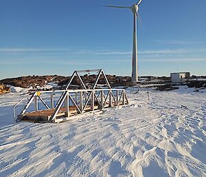 The new aluminium gantry that spans the melt bell area, sitting in the snow with a wind turbine behind