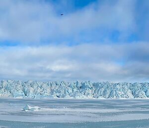 Panoramic shot of the Sorsdal Glacier, a large block of ice under a cloudy blue sky