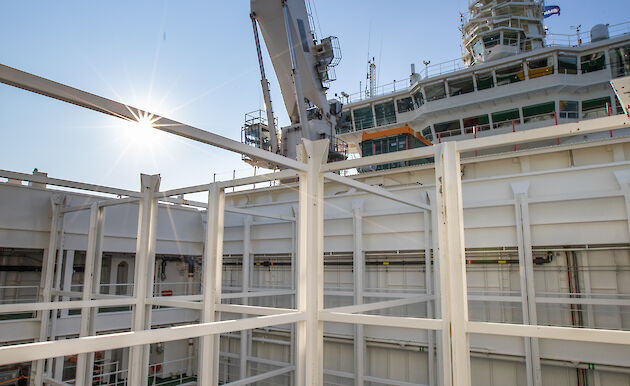 Ship based crane in operation against a blue sky