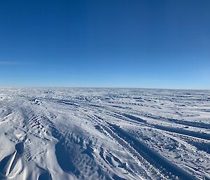 Panoramic shot of snow with the sun low on the horizon