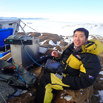 Expeditioner working on electrical equipment out in the field.