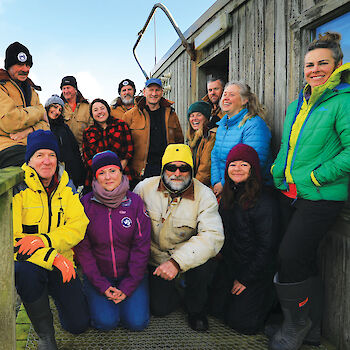 Group of expeditioners standing outside building on Macquarie Island.