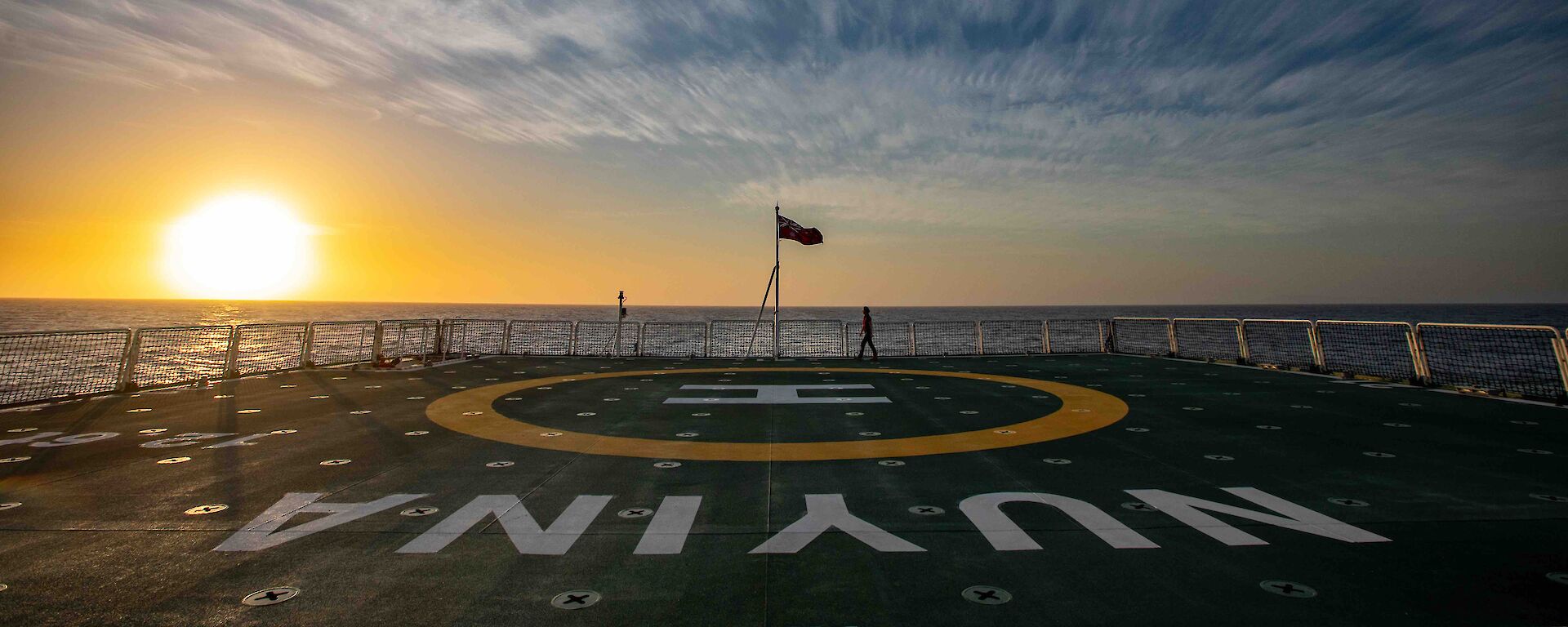 Looking across the helideck of a ship towards a sunset