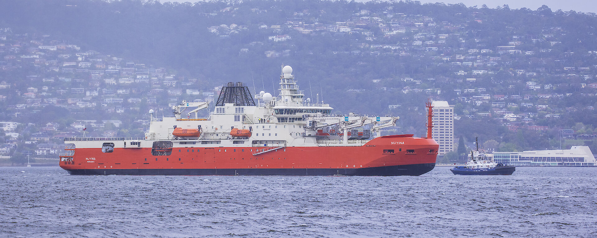 Nuyina in front of Hobart waterfront residences