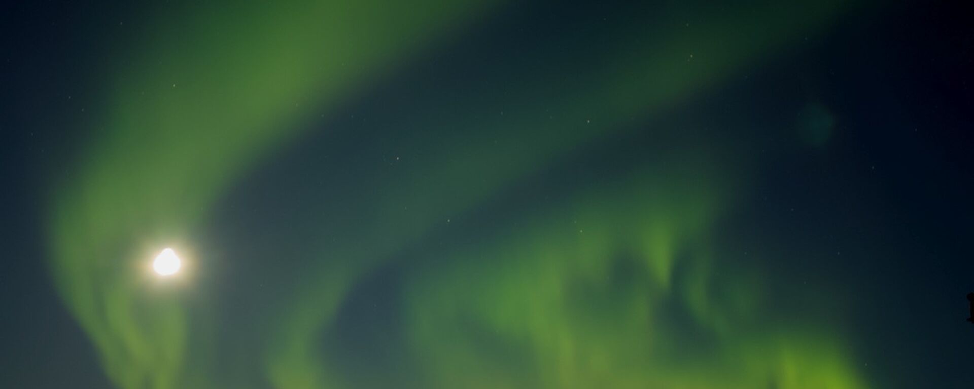 A green aurora floating across the night sky.