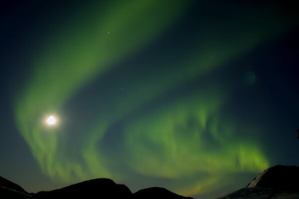 A green aurora floating across the night sky.