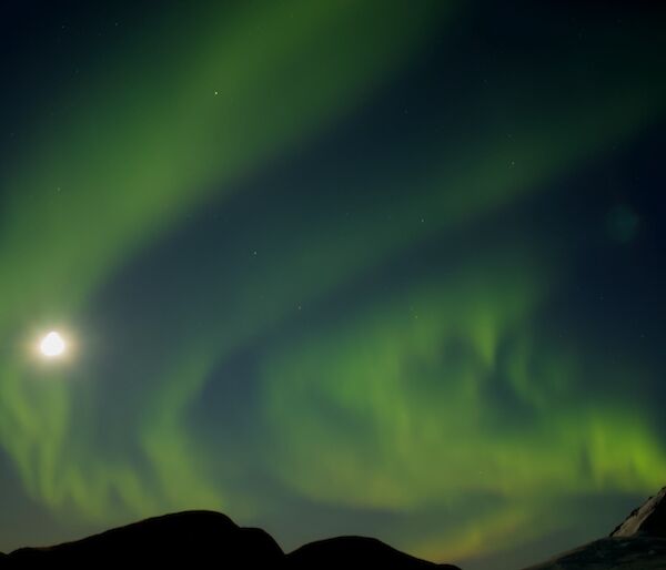 A green aurora floating across the night sky.