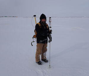 A man with a snow depth profile device