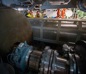 The flywheel of the ship's engine being checked by two workers