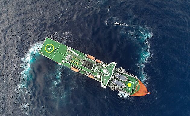 Aerial shot of the ship turning sharply in the ocean