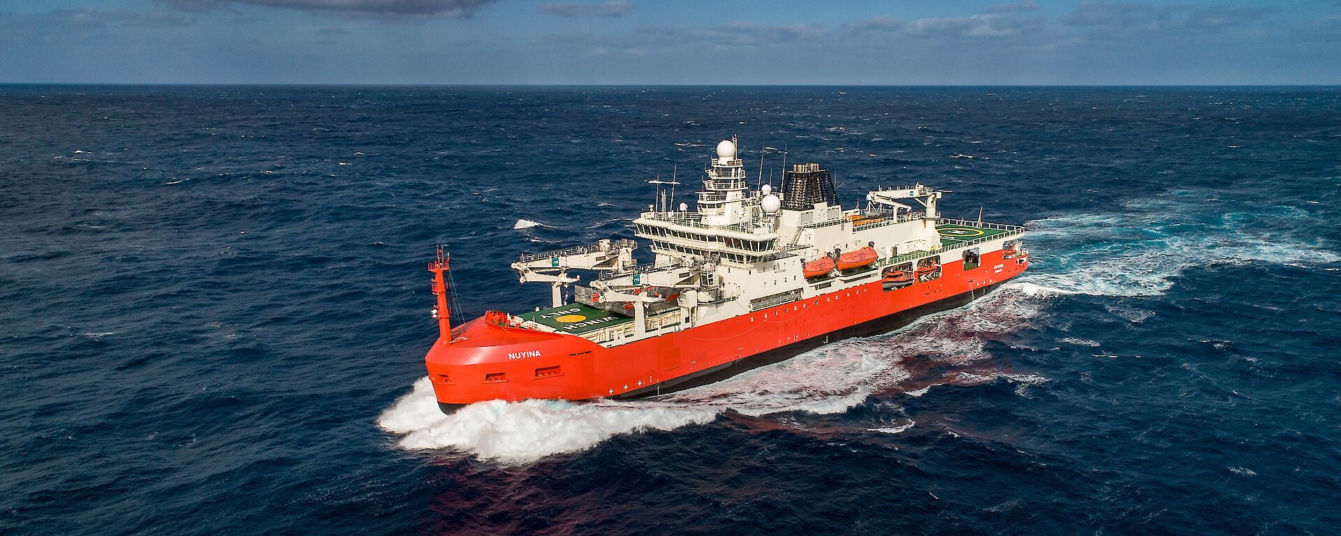 Large red and white ship making it's way across the ocean